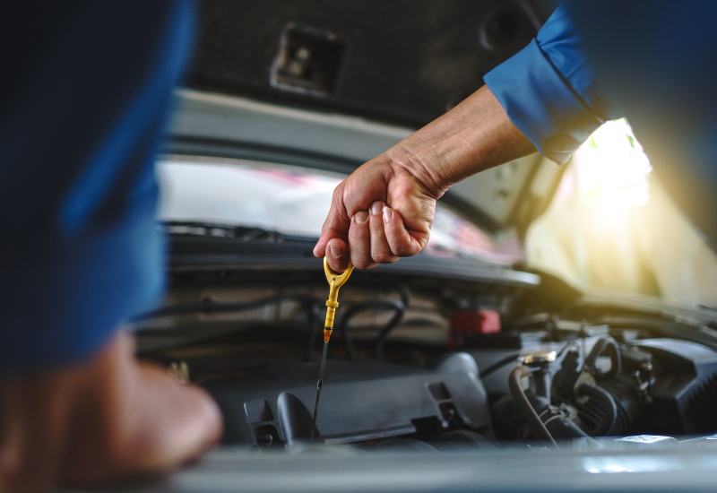 Mechanic checking engine oil level at Red River Oil Company in Texas & Arkansas